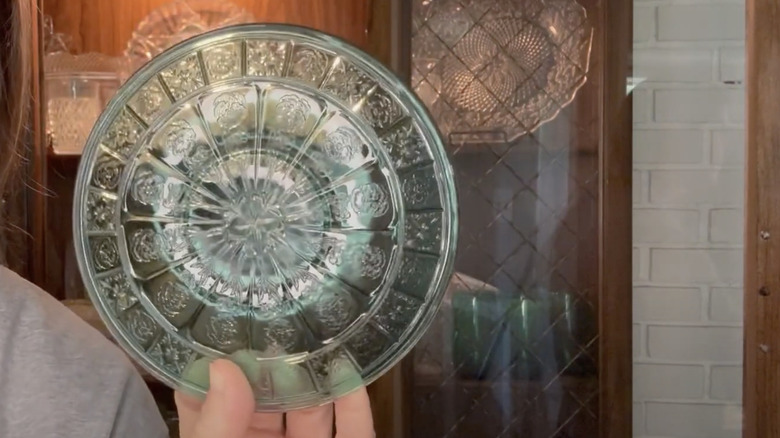 A collector holds a plate in the rare Doric and Pansy pattern by Jeannette Glass Company