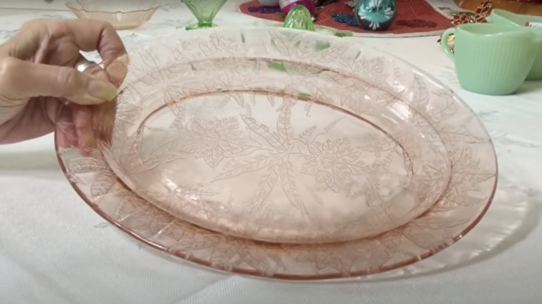 A collector holds a pink serving dish in the Floral pattern by Jeannette Glass Company