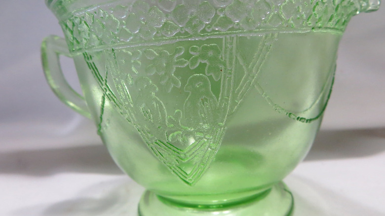 A green creamer by Federal Glass Company features the pattern Georgian or Lovebirds.