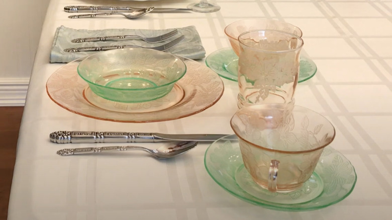 A dinner table set with pink and green pieces in the Dogwood pattern by Macbeth Evans Glass Company