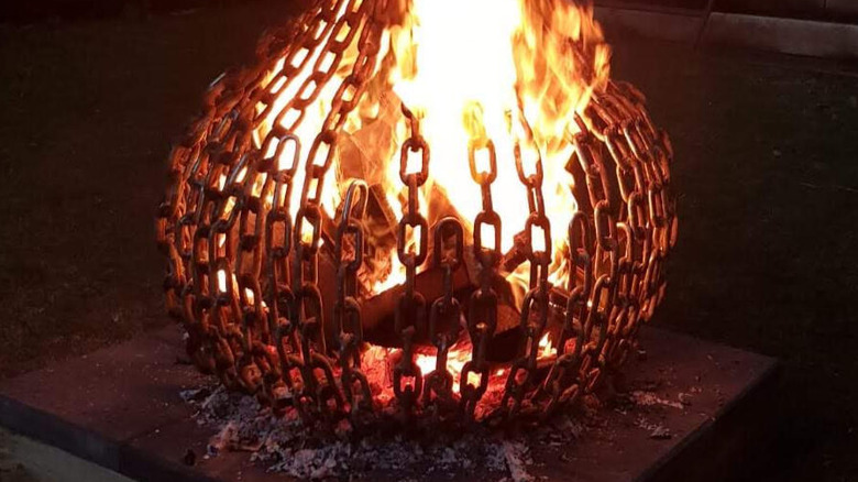 Fire burn bright inside a fire pit bowl made from heavy metal chain.