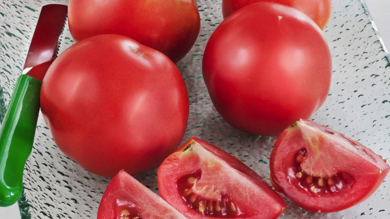 'Early Girl' tomatoes on a glass plate with a knife