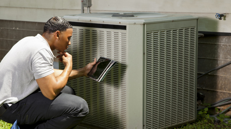 an inspector looks at a newly installed air conditioning unit