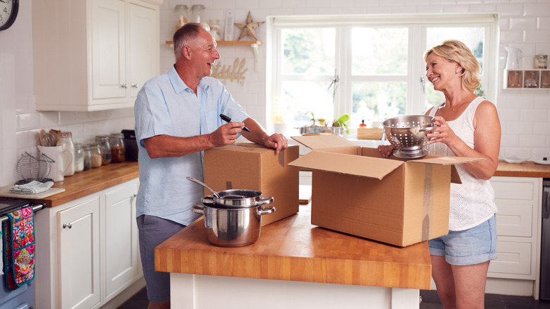 couple packing kitchen in boxes