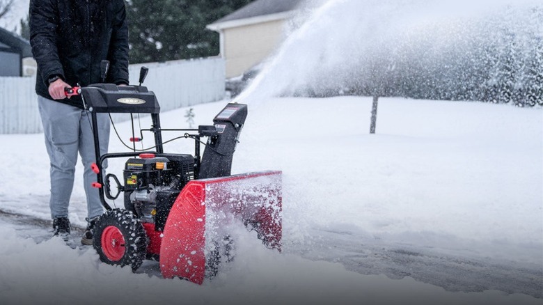 A person clearing the sidewalk with a PowerSmart snow blower