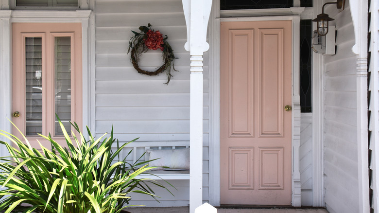 Two front doors are painted pale pink