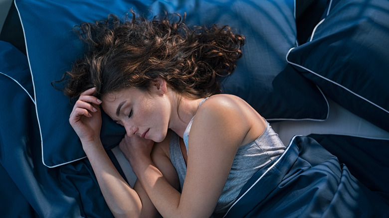Woman sleeping on blue bedding