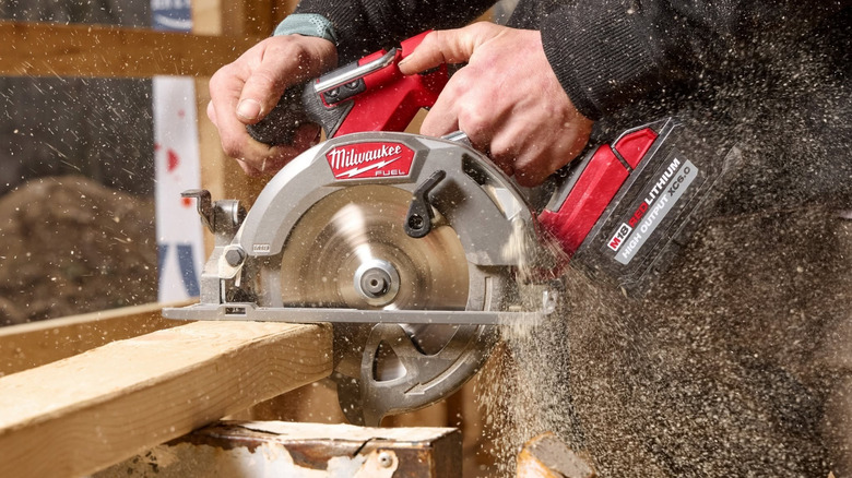 Person using a Milwaukee circular saw