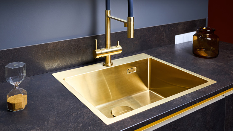dark countertop with shiny gold sink