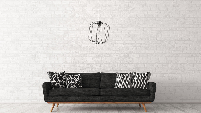 Black couch with plain backdrop