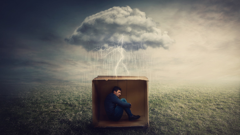 man in box with storm overhead