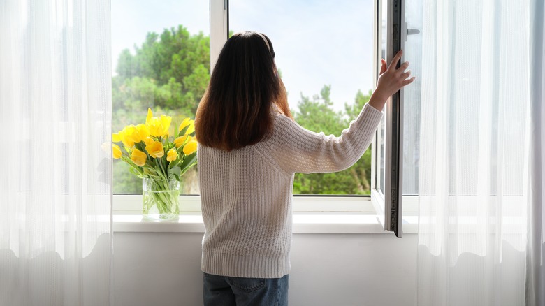 woman opening windows