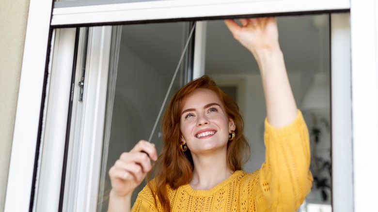 Woman holding retractable insect screen