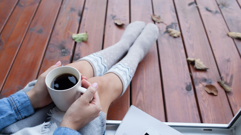 Girl holding coffee outside