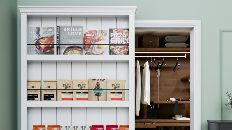 A hidden door behind a rolling shelf full of books and coffee.