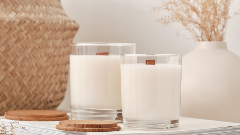 unlit white candles on magazines