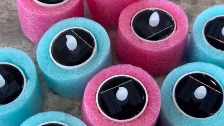 Floating tea lights in pool at night.