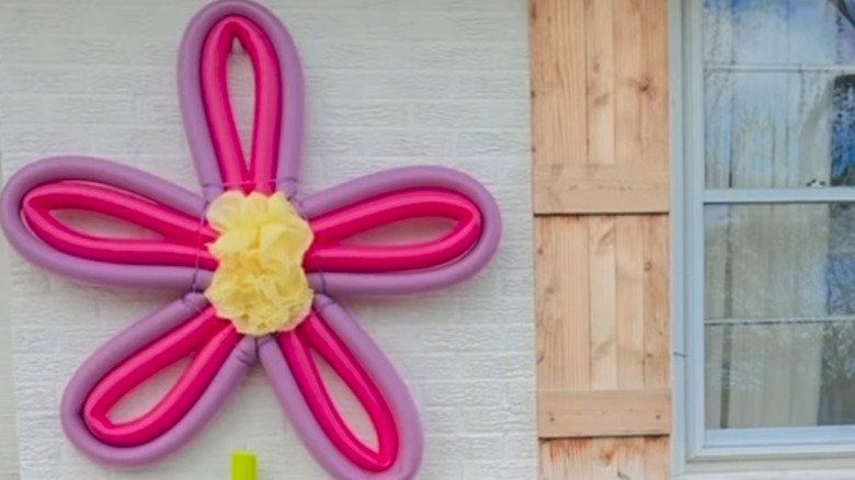 Pool noodle flower decor on house siding