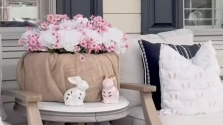 A burlap planter with pink and white flowers.