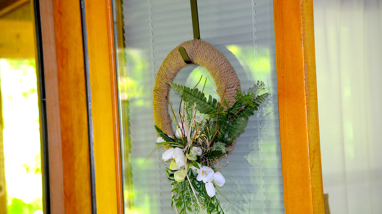 Round rustic wreath hanging on the door.