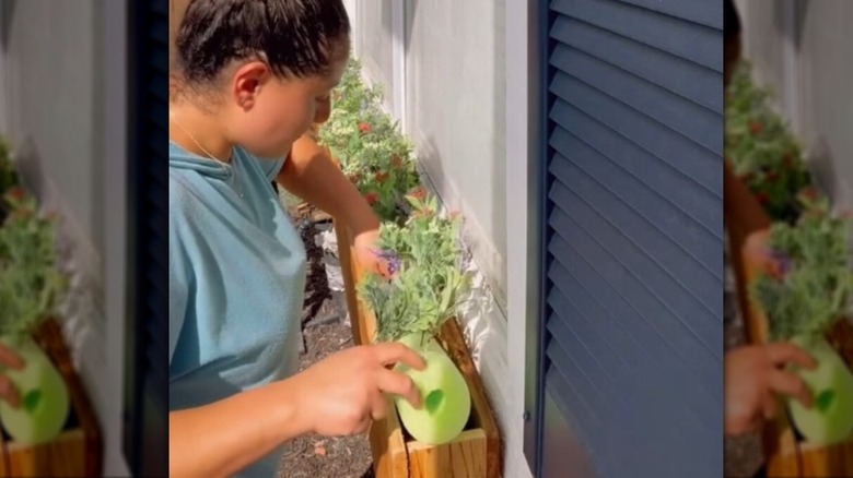 using pool noodles to hold faux plants for window planter