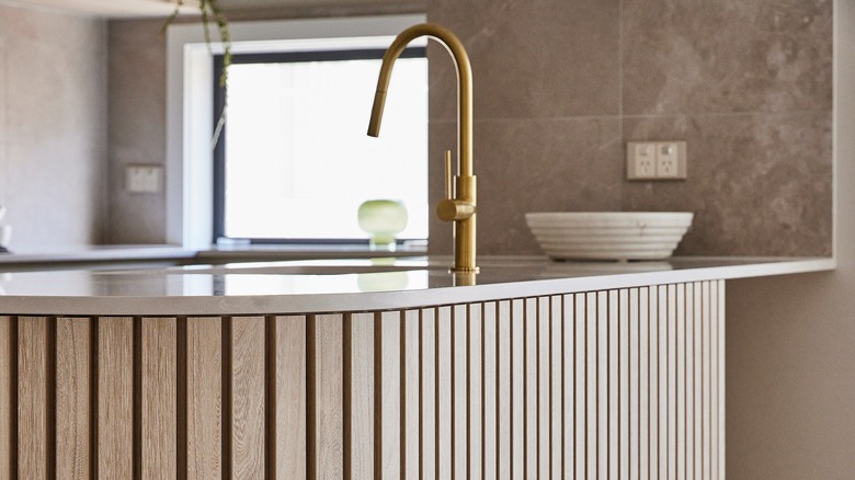 Fluted wood paneling in kitchen base cabinet