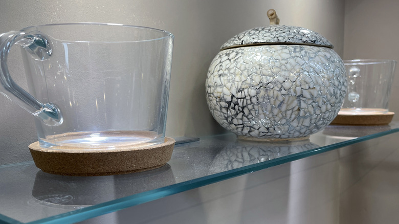 Floating glass shelves holding kitchen items.