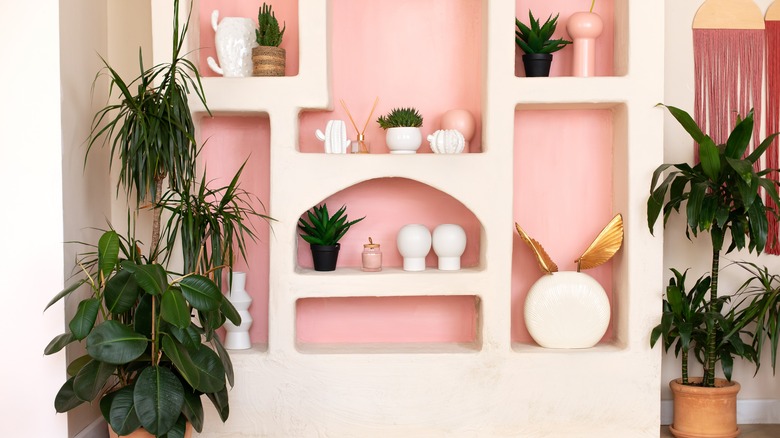 A pink and white Memphis style decor with plants.