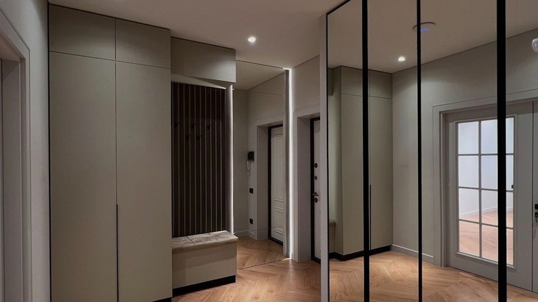 A hallway area with a mirrored wall.