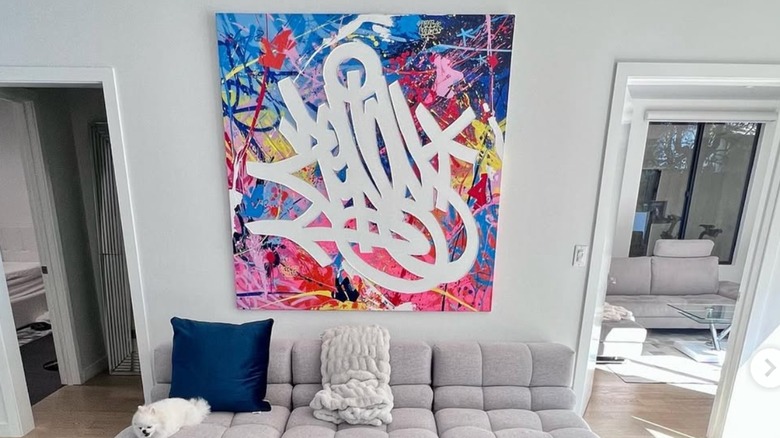 Neo pop art canvas above cray couch.