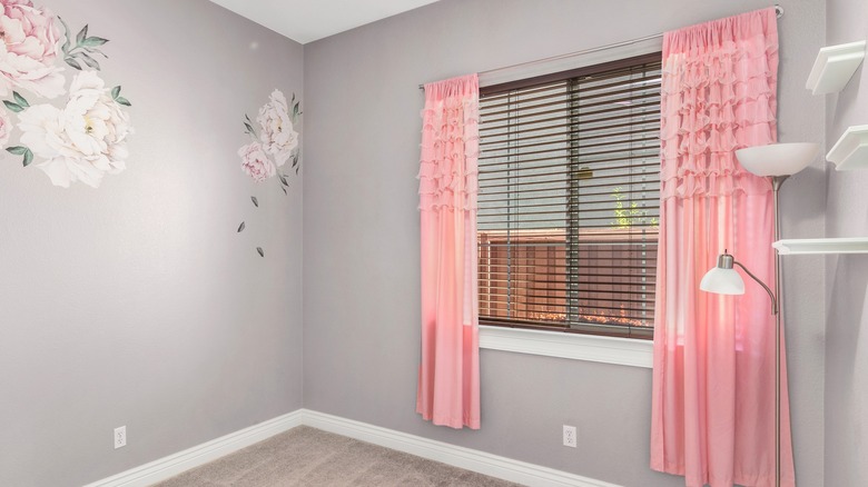 Pink ruffle curtains in floral gray room.