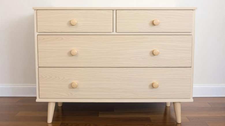 A light tan dresser with wooden knobs.