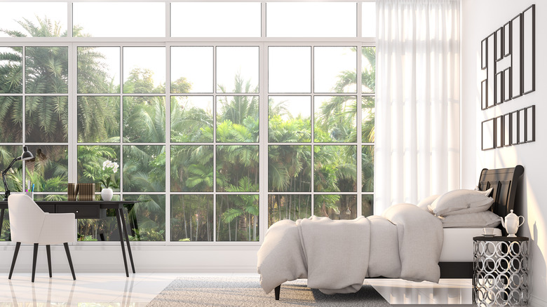 bright bedroom with palm trees outside window