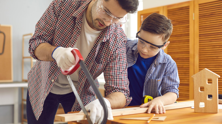 man and child cutting wood