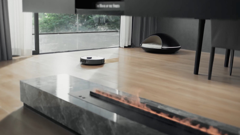 A 3i P10 Ultra robotic vacuum and mop cleaning wood floors in a modern house
