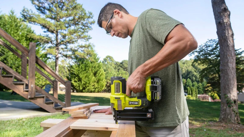Man using the Ryobi ONE+ Brad Nailer on a woodworking project outside