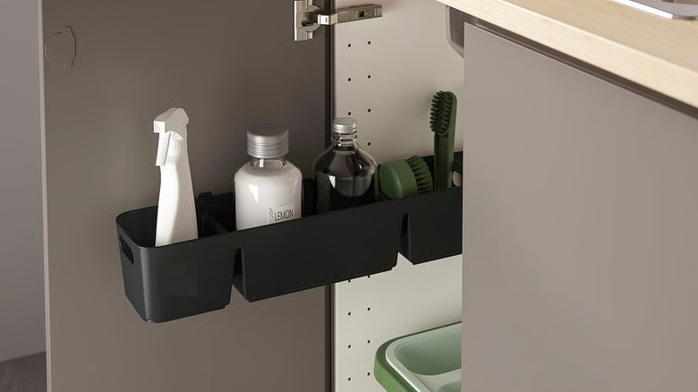 Small sliding drawer in cabinet with cleaning supplies