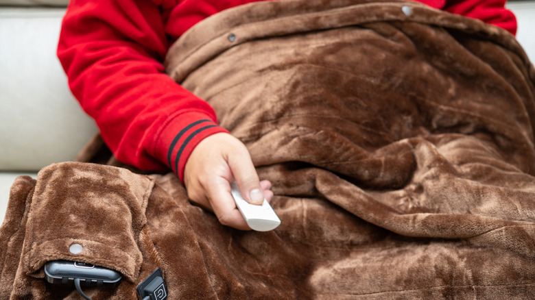a man using a remote to control an electric blanket