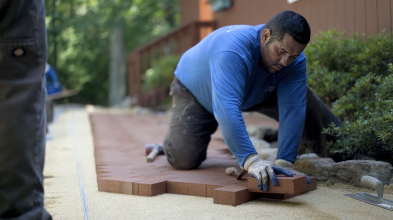 man installing patio pavers