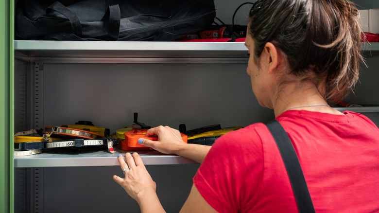 Woman organizing items on a garage shelf