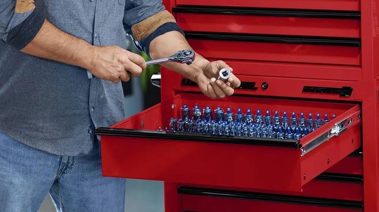 Man using a rolling tool cabinet from Harbor Freight
