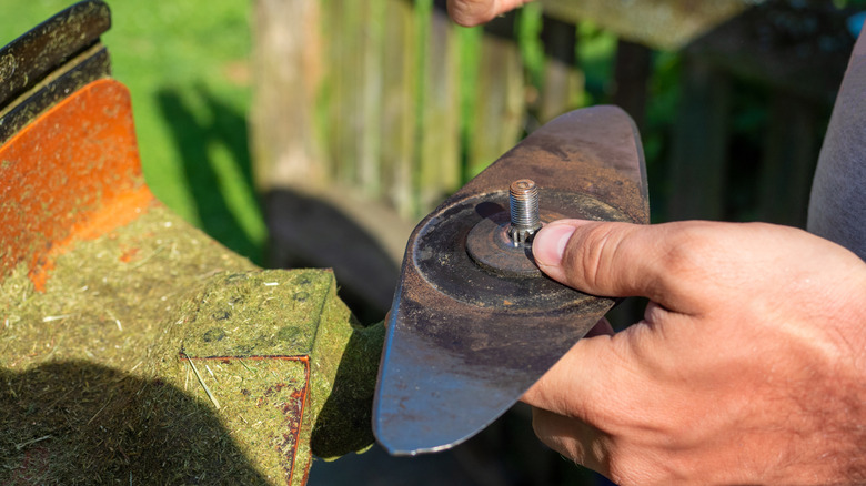 Adjusting mower blade