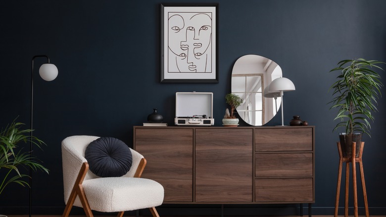 dark walls and wooden sideboard