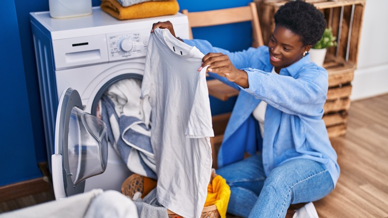 Woman holding up white laundry
