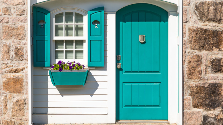 white cottage with teal shutters