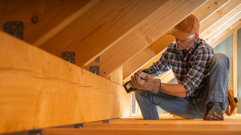Man working in tight space in attic