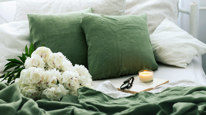 candles and flowers on green bedding