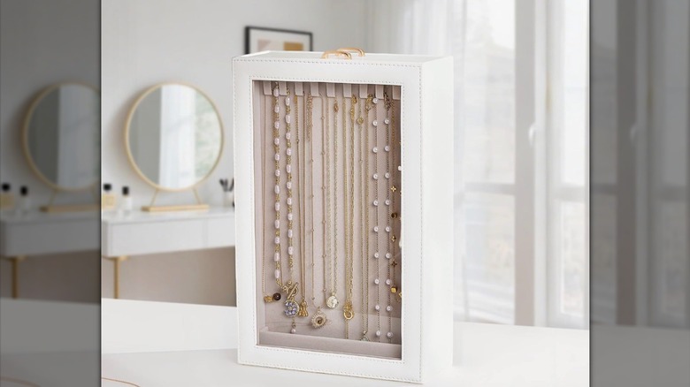 A white Lolalet necklace organizing box standing up vertically showing necklaces inside