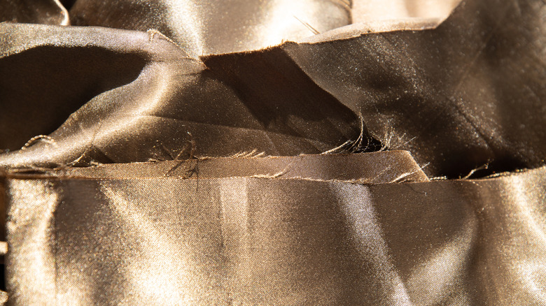 A close up of torn, brown silk material.