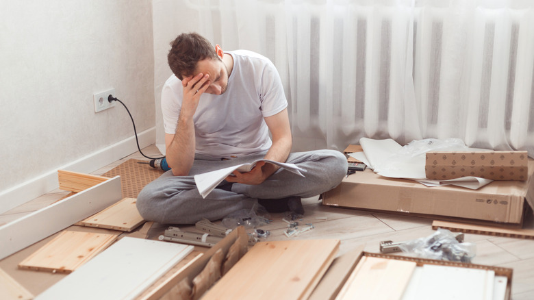 Man looking at product assembly instructions
